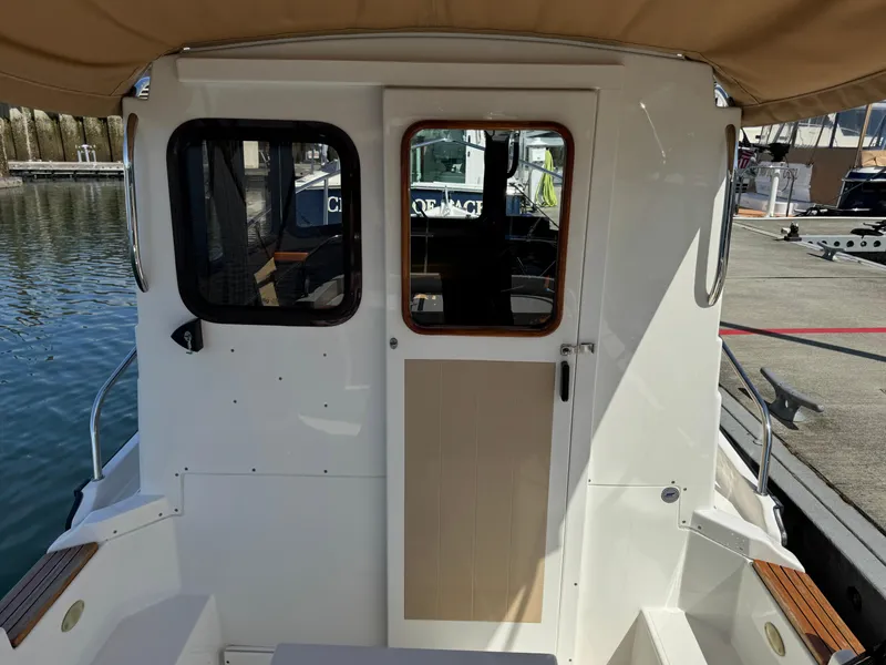 Slide: The Image of 2016 Ranger Tugs R-21EC boat stern view at dock, showcasing cabin entrance. - 10