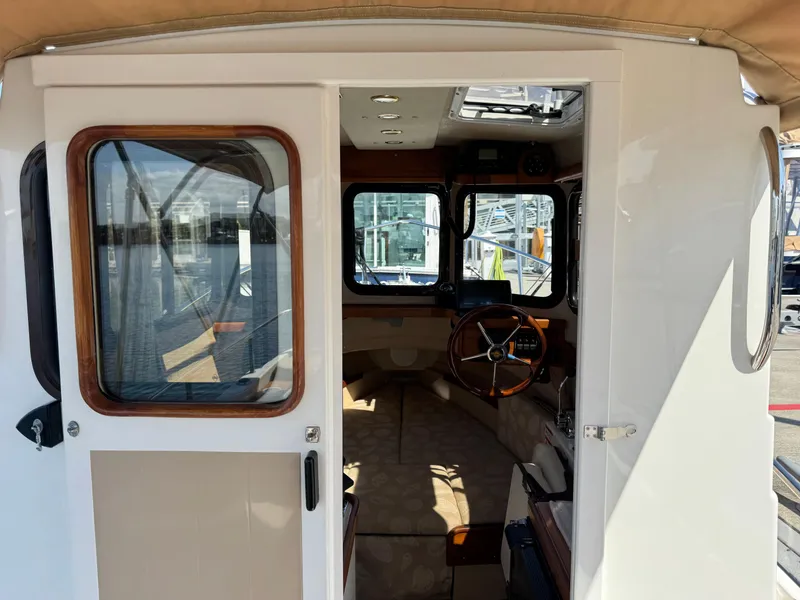 Slide: The Image of Interior view of 2016 Ranger Tugs R-21EC boat, featuring helm and seating area. - 11