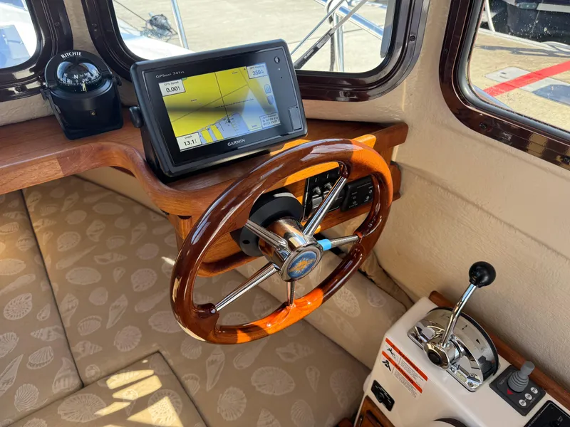 Slide: The Image of 2016 Ranger Tugs R-21EC helm with GPS, compass, and throttle controls. - 14