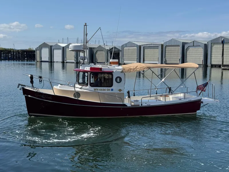 Slide: The Image of 2016 Ranger Tugs R-21EC boat cruising near docks on a sunny day. - 2