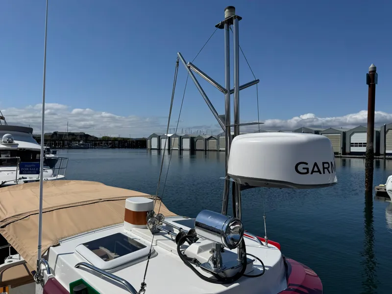 Slide: The Image of 2016 Ranger Tugs R-21EC boat with Garmin radar, docked in a marina under clear skies. - 29
