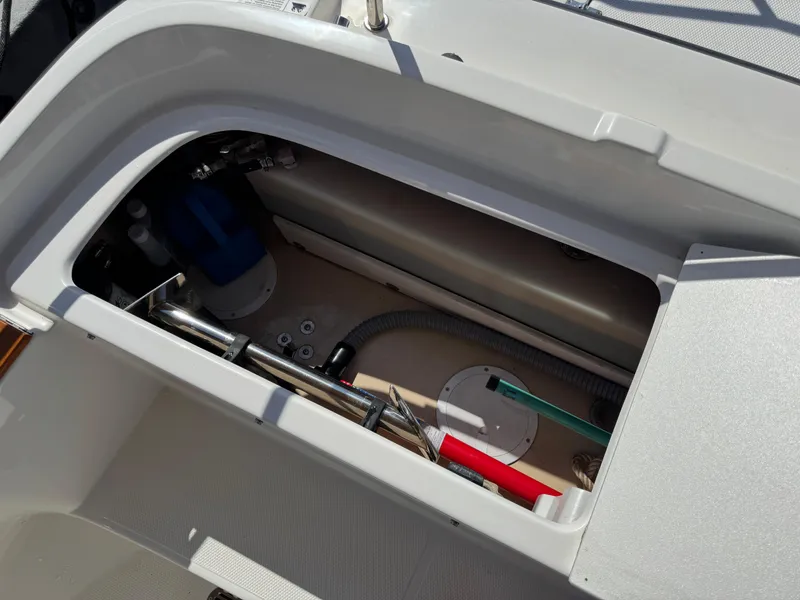Slide: The Image of 2016 Ranger Tugs R-21EC storage compartment with mechanical components and tools. - 33