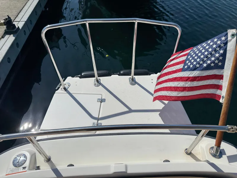 Slide: The Image of 2016 Ranger Tugs R-21EC boat stern with American flag at dock. - 34