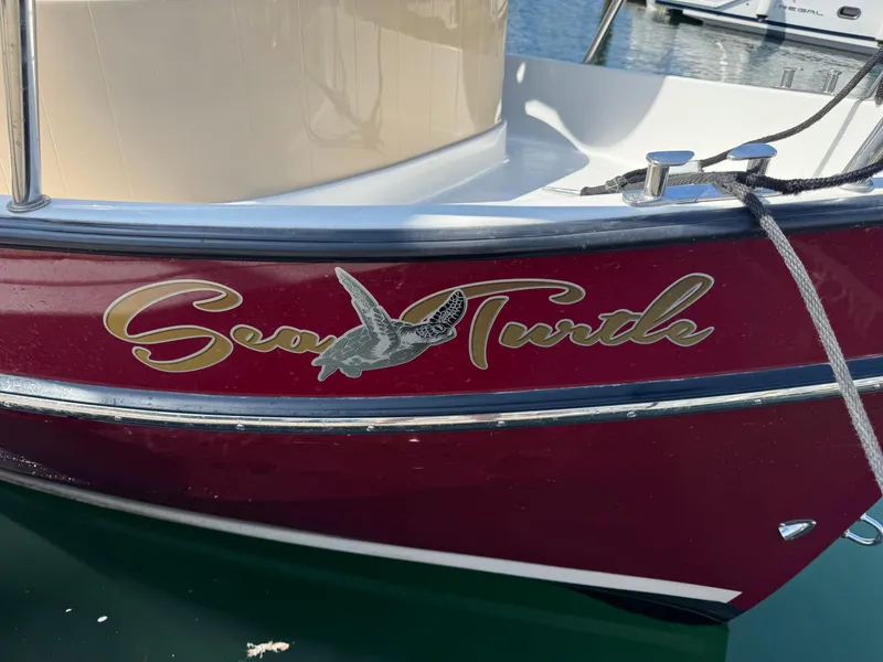 Slide: The Image of 2016 Ranger Tugs R-21EC boat with "Sea Turtle" decal on red hull. - 5