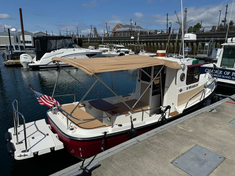 Slide: The Image of 2016 Ranger Tugs R-21EC boat docked at marina with canopy and American flag. - 6