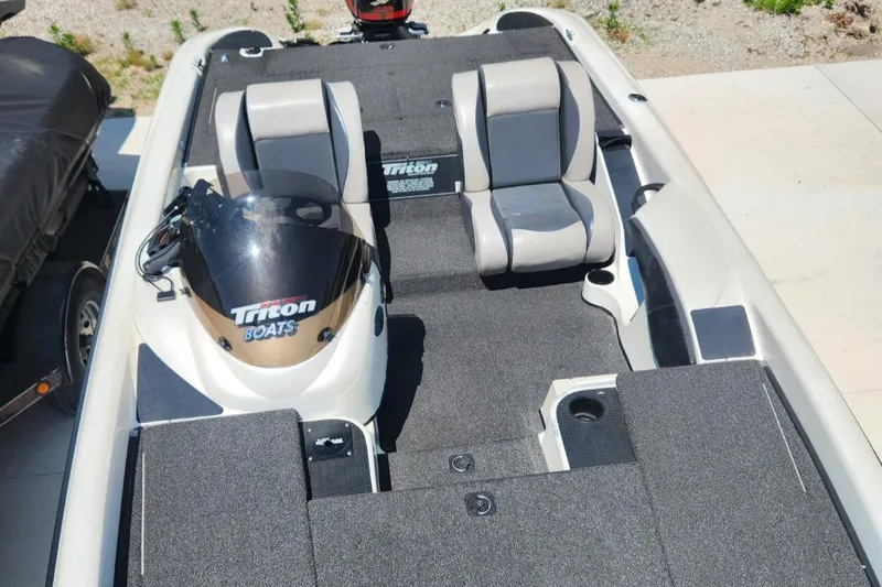 Slide: The Image of 2001 Triton TR21 boat interior with dual seats and steering console. - 21