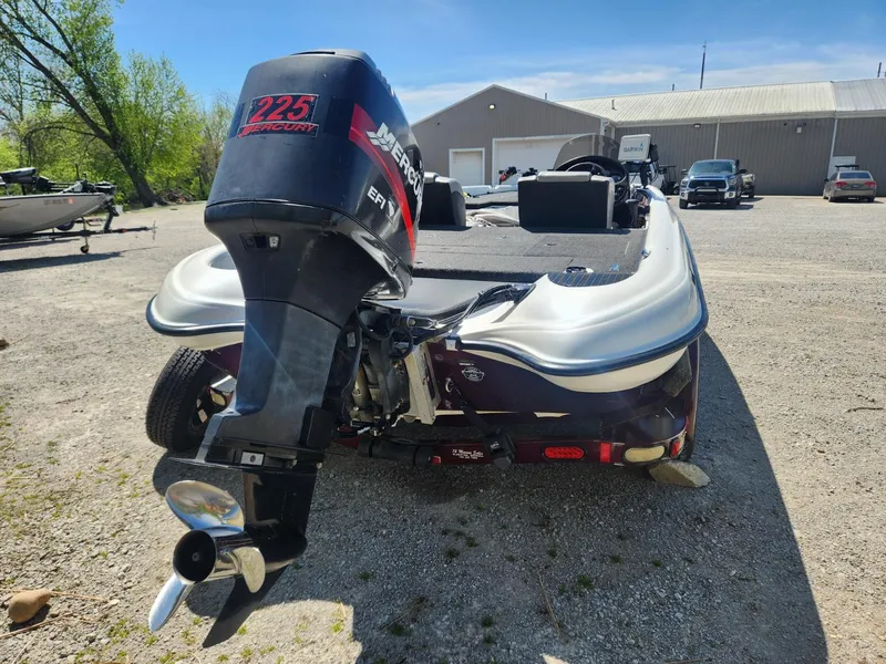 Slide: The Image of 2000 Triton TR21 boat with Mercury 225 engine in a parking lot. - 6