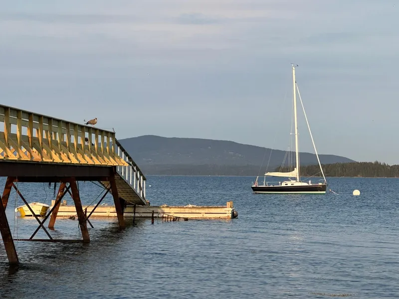 Slide: The Image of Sailboat Tartan Fantail 2014 anchored near a wooden pier on a serene lake. - 10