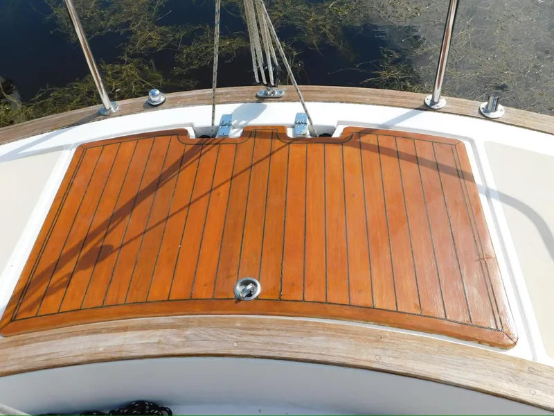 Slide: The Image of Wooden deck of a 2014 Tartan Fantail sailboat, featuring polished finish and metal fittings. - 13