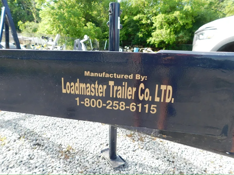 Slide: The Image of Trailer by Loadmaster Trailer Co. LTD, contact number displayed, gravel ground, trees in background. - 22