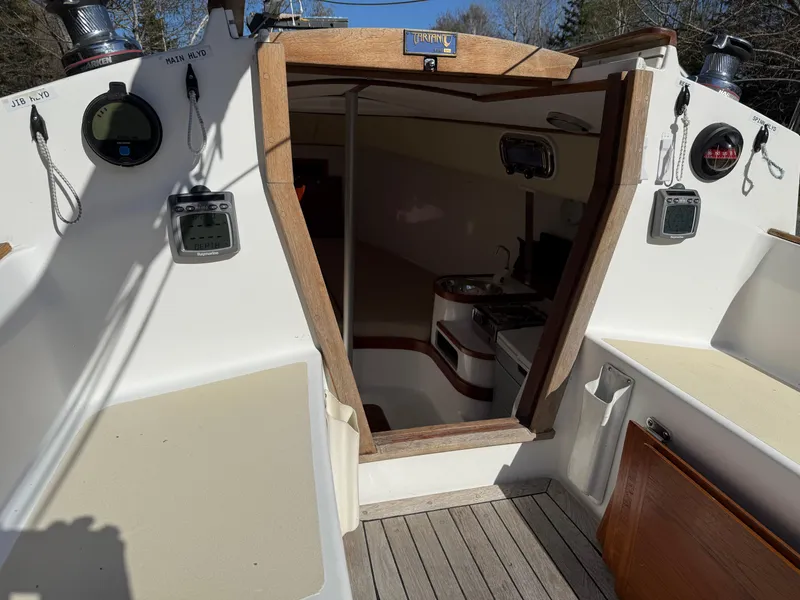 Slide: The Image of 2014 Tartan Fantail sailboat cockpit with open cabin door, showcasing interior and navigation instruments. - 31