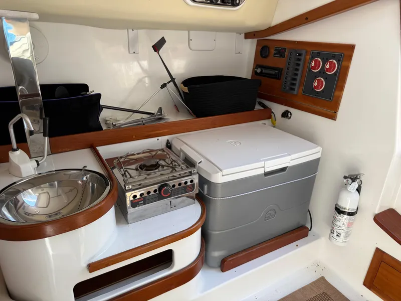 Slide: The Image of 2014 Tartan Fantail boat interior with kitchenette, stove, cooler, and control panel. - 34