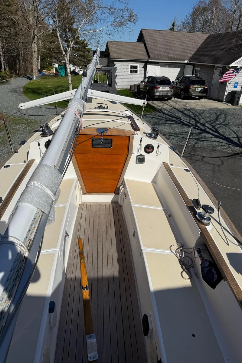 Slide: The Image of 2014 Tartan Fantail sailboat with wooden deck, docked near a house and parked cars. - 35
