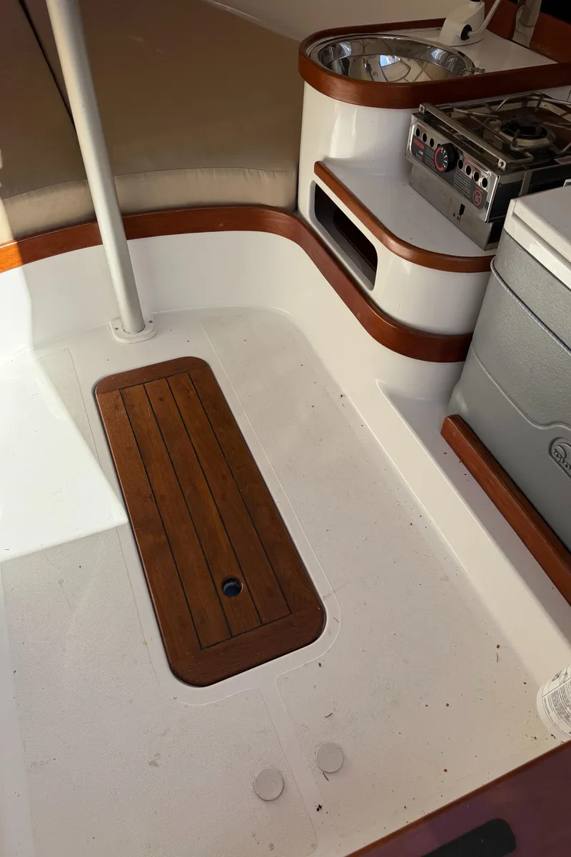 Slide: The Image of 2014 Tartan Fantail boat interior with wood accents and compact kitchen area. - 37