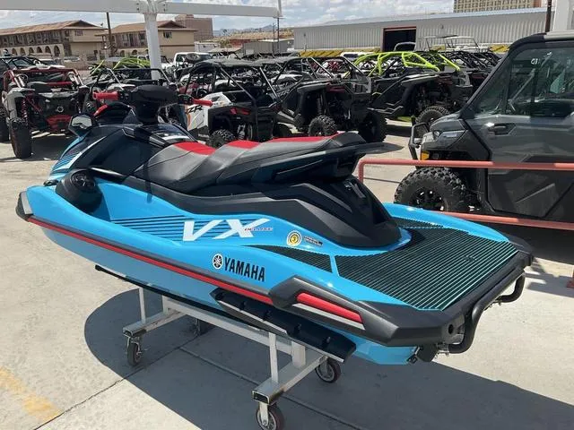 Slide: The Image of 2024 Yamaha Waverunner VX Deluxe with Audio, blue, displayed outdoors among other vehicles. - 4