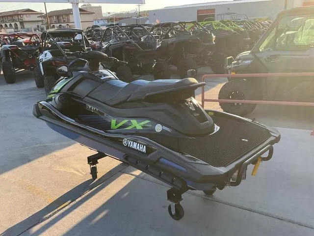 Slide: The Image of 2024 Yamaha Waverunner VX® Deluxe with Audio, parked outdoors, surrounded by other vehicles. - 4
