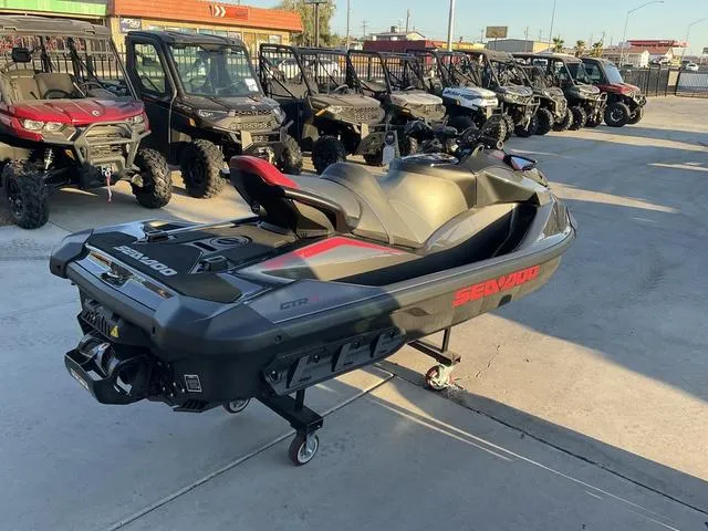 Slide: The Image of 2024 Sea-Doo Waverunner GTR-X 300 Ibr displayed outdoors with other vehicles. - 3