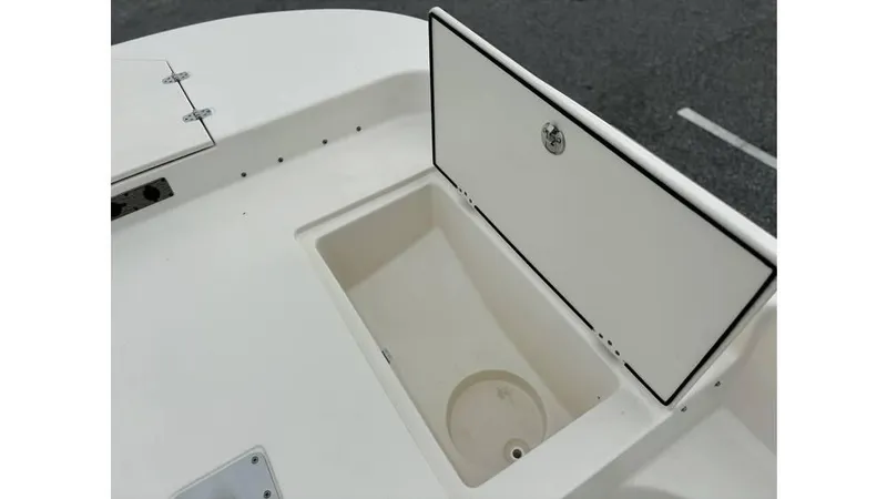 Slide: The Image of 2025 Carolina Skiff 21 LS boat storage compartment, open lid, white interior. - 12
