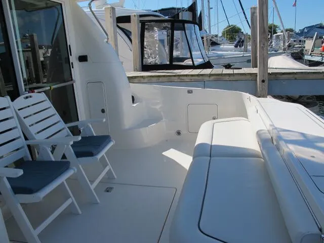 Slide: The Image of 1998 Sea Ray 480 Sedan Bridge yacht deck with seating and marina view. - 10