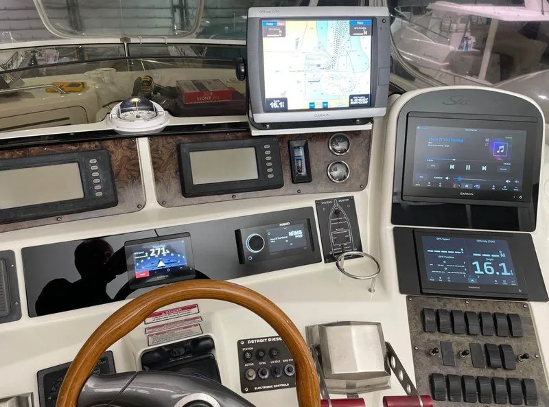 Slide: The Image of 1998 Sea Ray 480 Sedan Bridge helm with navigation screens and controls. - 16