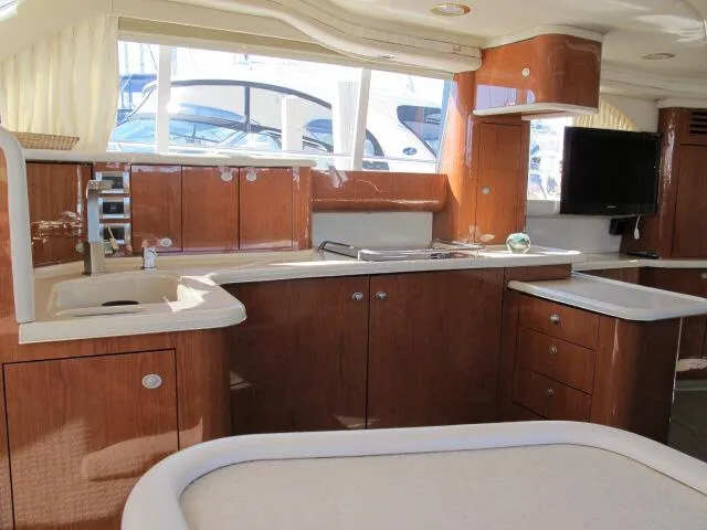 Slide: The Image of Interior of 1998 Sea Ray 480 Sedan Bridge yacht with wooden cabinetry and modern amenities. - 2