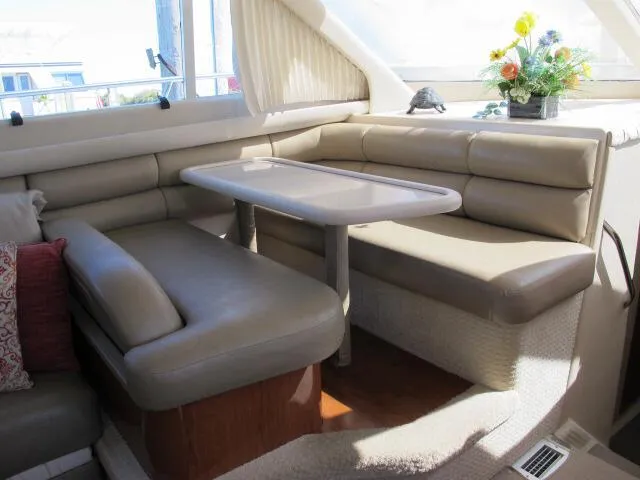 Slide: The Image of Interior of 1998 Sea Ray 480 Sedan Bridge with beige seating and table. - 4