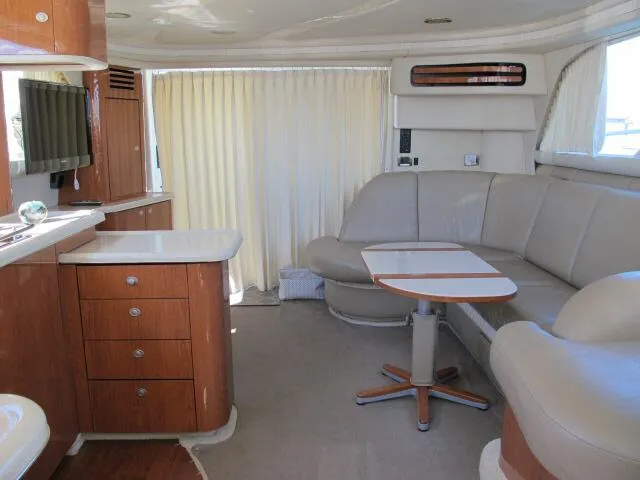 Slide: The Image of Interior of 1998 Sea Ray 480 Sedan Bridge yacht with beige seating and wooden cabinetry. - 5