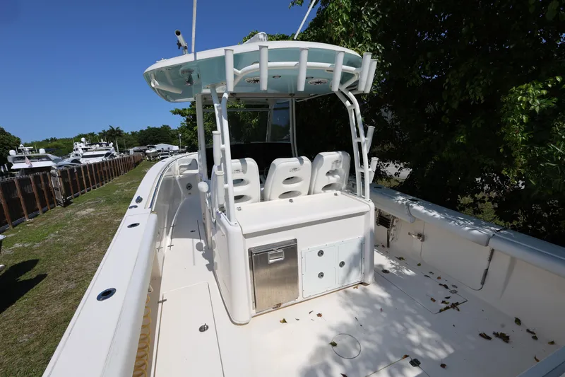 Slide: The Image of 2020 Cobia 350 Center Console boat with seating and storage, docked near trees. - 10