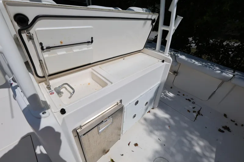 Slide: The Image of 2020 Cobia 350 Center Console boat with open storage compartment and clean deck. - 11