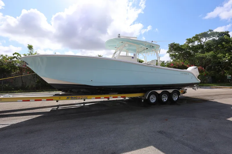 Slide: The Image of 2020 Cobia 350 Center Console boat on trailer under a sunny sky. - 2