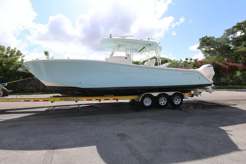 Slide: The Image of 2020 Cobia 350 Center Console boat on trailer under a partly cloudy sky. - 3