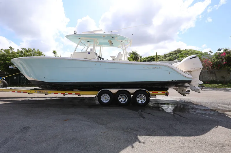 Slide: The Image of 2020 Cobia 350 Center Console boat on a trailer, parked outdoors under a cloudy sky. - 4
