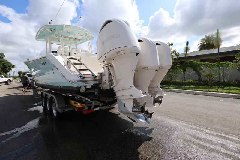 Slide: The Image of 2020 Cobia 350 Center Console boat on trailer with triple outboard engines. - 5
