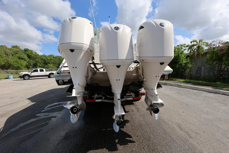 Slide: The Image of 2020 Cobia 350 Center Console with triple outboard engines, parked on a sunny day. - 6