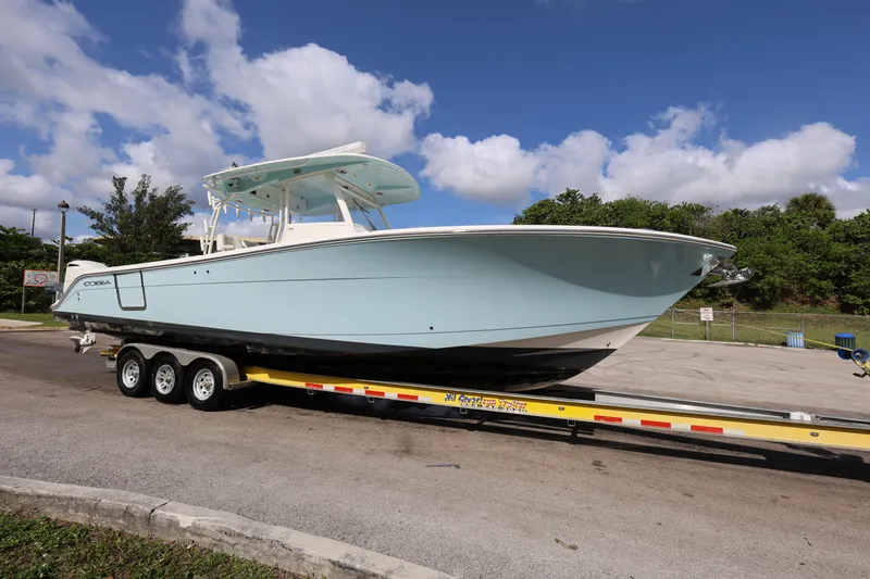Slide: The Image of 2020 Cobia 350 Center Console boat on trailer, parked outdoors under blue sky. - 9