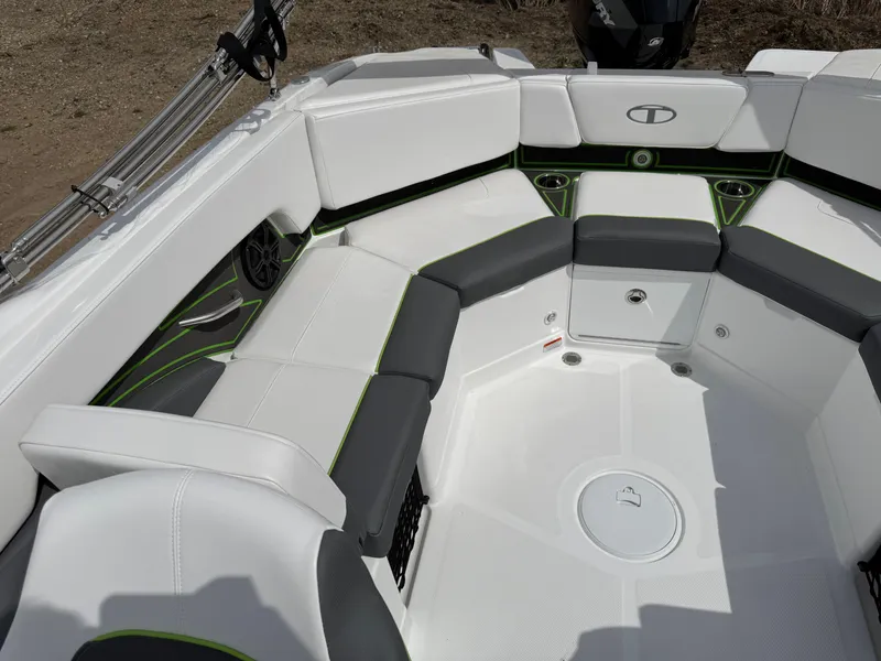 Slide: The Image of 2024 Tahoe 210 S boat interior with white and gray seating, green accents, and speaker. - 13