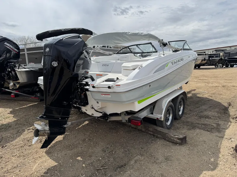 Slide: The Image of 2024 Tahoe 210 S boat on trailer in warehouse setting. - 2