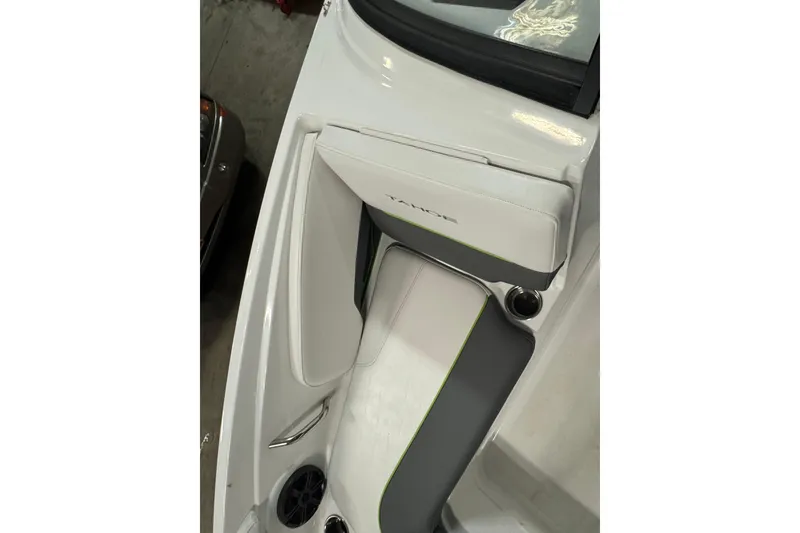 Slide: The Image of 2024 Tahoe 210 S boat interior with white and gray seating, cup holder, and speaker. - 21