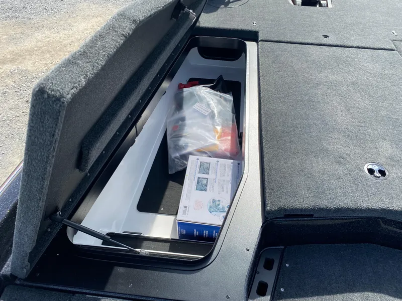 Slide: The Image of Storage compartment of 2025 Skeeter ZXR 20 boat with gear and manual inside. - 13