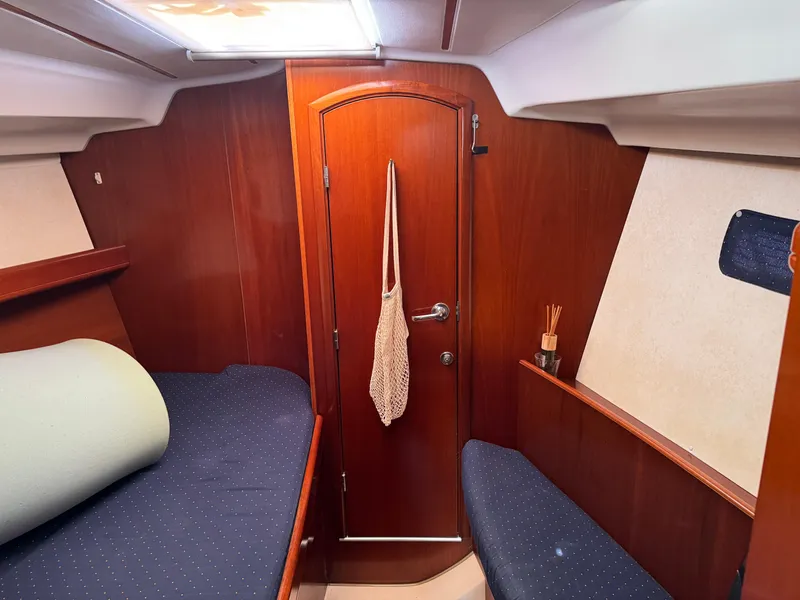Slide: The Image of Interior cabin of 2002 Beneteau Oceanis Clipper 393 sailboat, featuring wood paneling and cozy seating. - 10