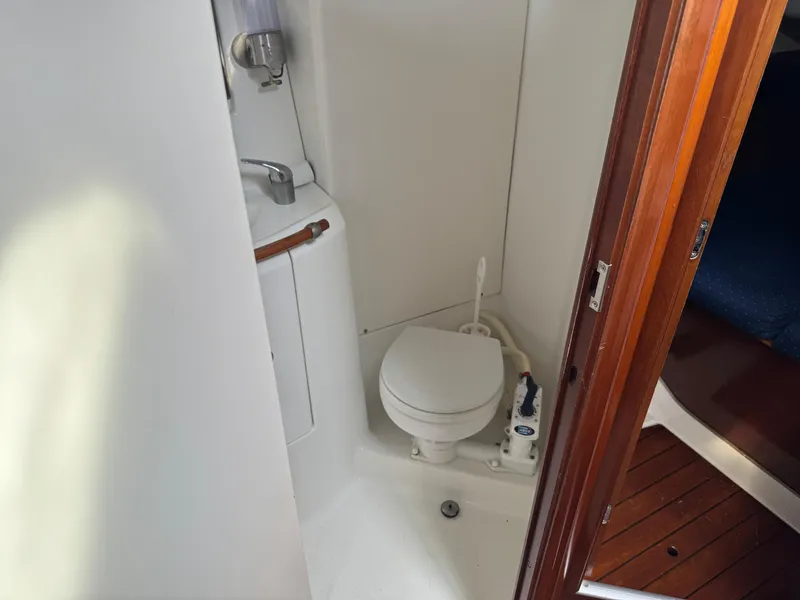 Slide: The Image of Compact bathroom in 2002 Beneteau Oceanis Clipper 393 sailboat, featuring toilet and sink. - 15