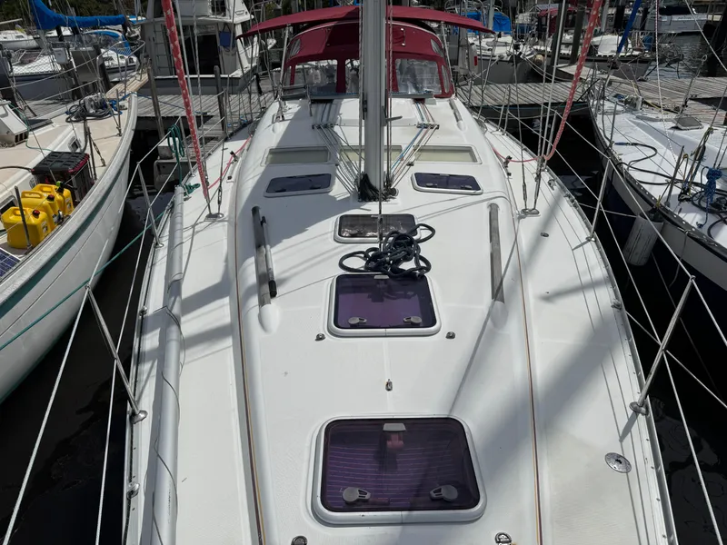 Slide: The Image of 2002 Beneteau Oceanis Clipper 393 sailboat docked, featuring a spacious deck and red canopy. - 30
