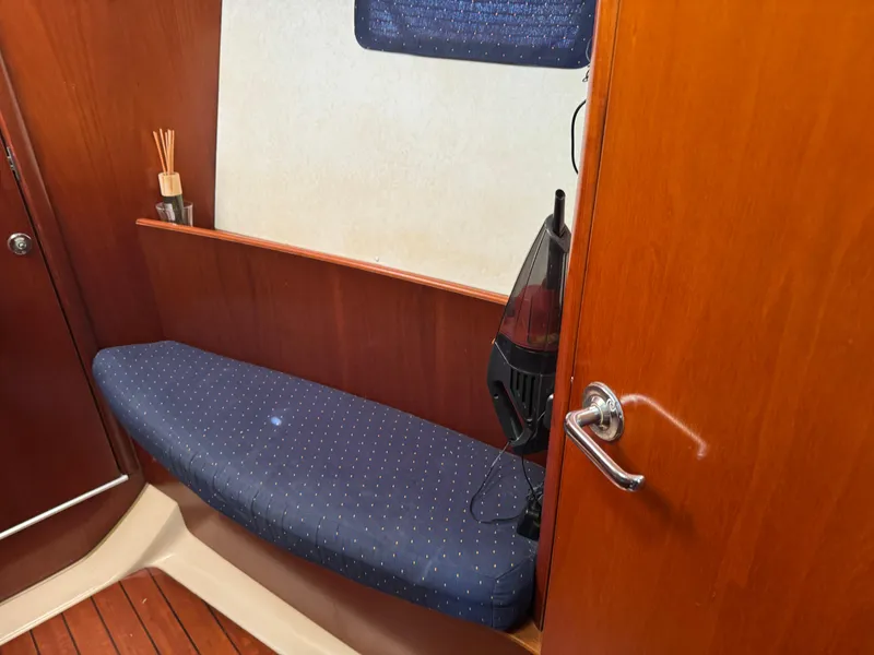 Slide: The Image of Interior of 2002 Beneteau Oceanis Clipper 393 with wooden finish and blue cushioned seating. - 5