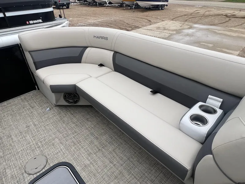 Slide: The Image of 2022 Harris Cruiser 230 boat interior with beige seating and cup holders. - 10
