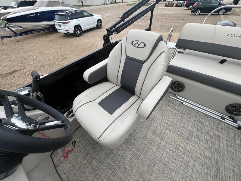 Slide: The Image of 2022 Harris Cruiser 230 boat interior with plush seating and steering wheel. - 13