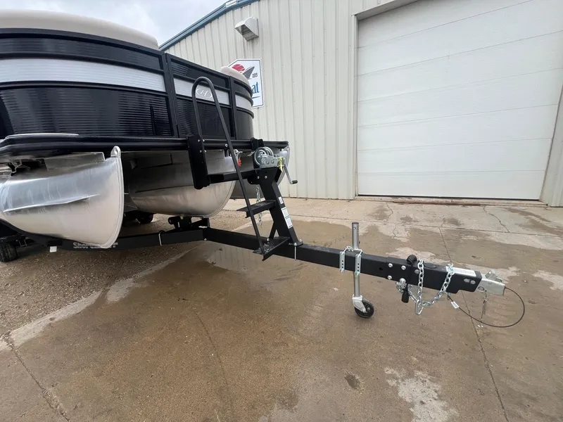 Slide: The Image of 2022 Harris Cruiser 230 pontoon boat on trailer outside a garage. - 28
