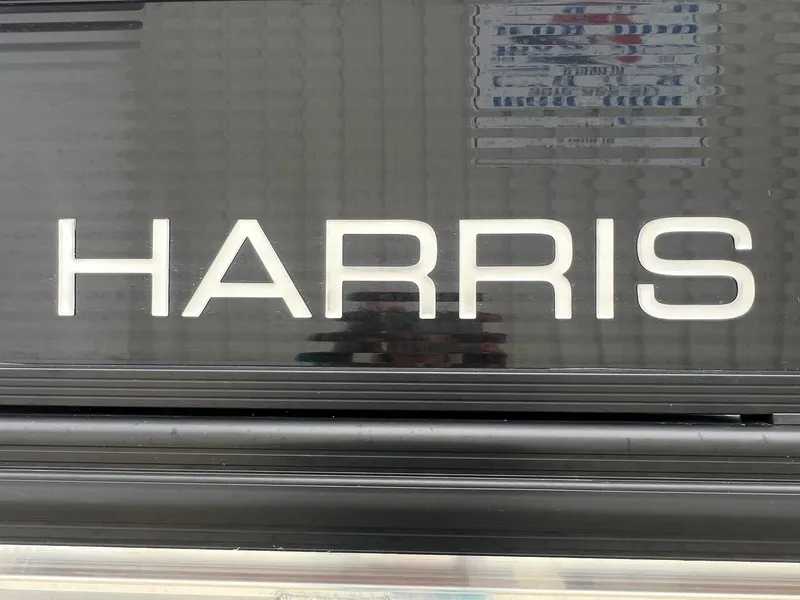 Slide: The Image of 2022 Harris Cruiser 230 boat logo on a sleek black surface. - 4