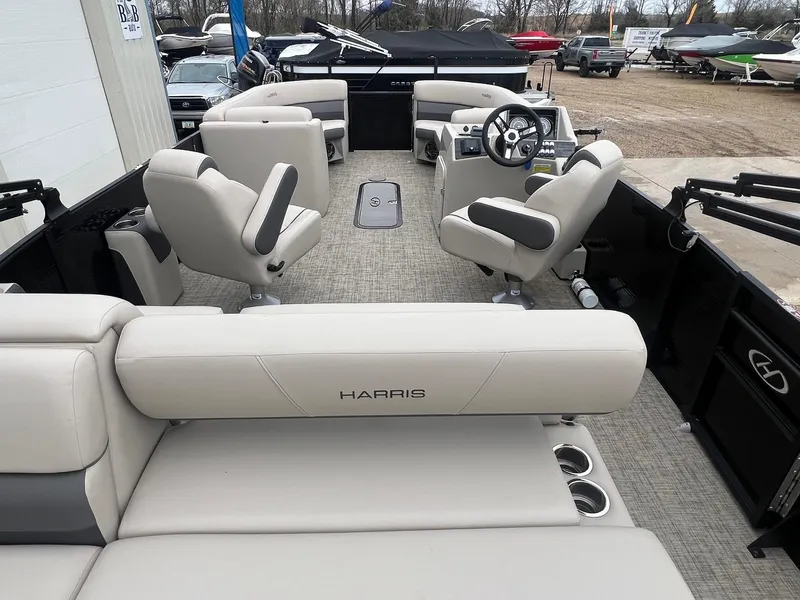 Slide: The Image of 2022 Harris Cruiser 230 boat interior with beige seating and steering console. - 8