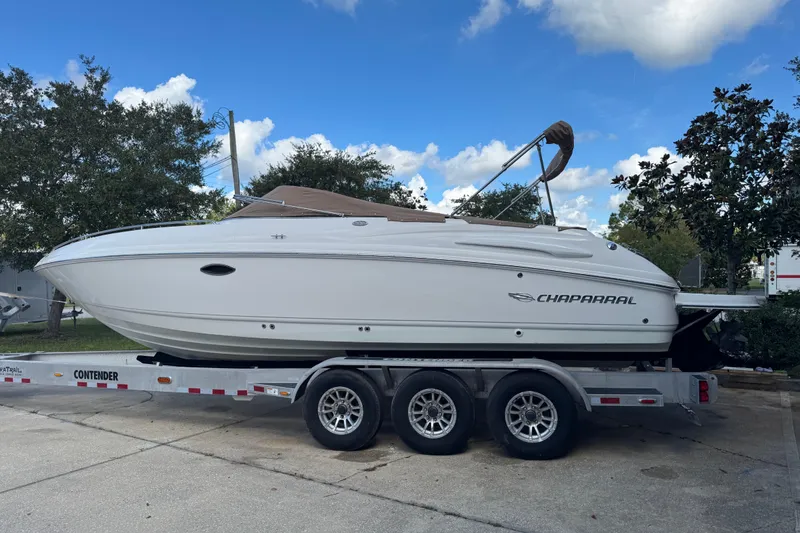 The Image of 2004 Chaparral 260 SSi boat on trailer, parked outdoors under blue sky. - 0