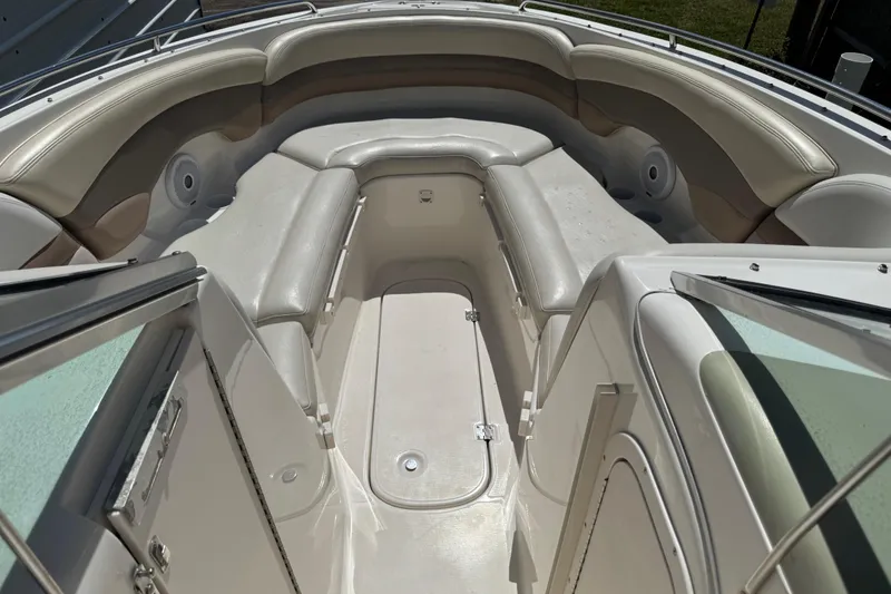 Slide: The Image of 2004 Chaparral 260 SSi boat interior with cushioned seating and open deck area. - 19
